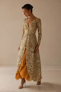 Gold long silk organza jacket with hand cutwork metallic pop floral embroidery. Comes with light mango inner chiffon ruffle gown.
Component: 2
Pattern: Embroidered
Type Of Work: Floral Pattern
Neckline: Jacket: Plunged V-Neck
Sleeve Type: Jacket: Straight Long
Fabric: Jacket : Silk Organza, Inner gown : Chiffon
Color: Gold, Yellow
Other Details: 
Floral cutwork jacket
Asymmetric ruffled gown
Occasion: Cocktail - Aza Fashions Gold Dress With Sleeves, Traditional Jackets For Women Indian, Indian Cocktail Outfits For Women, Indian Outfits Modern, Organza Jacket, Straight Jacket, Indian Dresses Traditional, Gaun Fashion, Traditional Indian Outfits