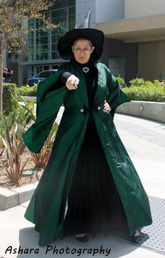 a woman in a green coat and black hat