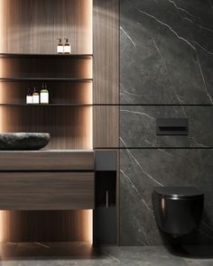 a bathroom with marble walls and flooring next to a black toilet in front of a wooden shelf