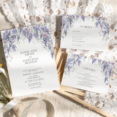 the wedding stationery is laid out on a lace doily with flowers and ribbons