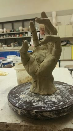 a clay hand sitting on top of a table