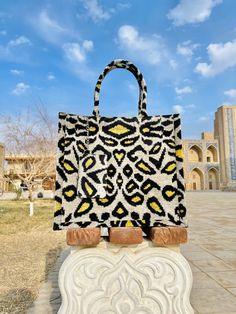 an animal print bag sitting on top of a cement block