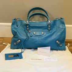 Excellent Condition! This Bag Is Discontinued! Balenciaga - Giant 21 Silver, Work Motorcycle Tote Bag In Sky Blue. Distressed Lamb Skin Leather, Textured Silver Tone Thimble Shaped Studs (This Style Is No Longer Used), Silver Tone Hardware, 1 Outside Zippered Pocket, Detachable Mirror, 1 Inside Zippered Pocket W/Leather Label Attached, 2 Rolled Leather Handles W/Matching Whip Stitched Edges. Wear On Bottom Edges & Handles; Leather Is Distressed So Blends In Well. Dust Bag & Cards Included. Pleas Luxury Blue Satchel With Silver-tone Hardware, Designer Blue Satchel For Travel, Luxury Blue Satchel With Palladium Hardware, Designer Travel Shoulder Bag With Silver-tone Hardware, Designer Shoulder Bag With Silver-tone Hardware, Designer Shoulder Bag With Silver-tone Hardware For Shopping, Blue Satchel With Palladium Hardware, Designer Travel Satchel With Silver-tone Hardware, Designer Satchel With Silver-tone Hardware And Double Handle