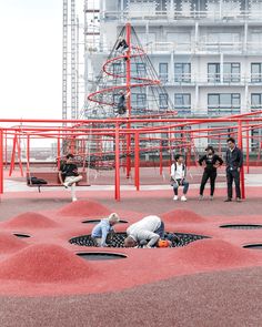 children playing in an empty playground with red paint on the ground