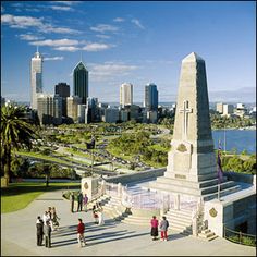 people are standing in front of a monument with a cityscape in the background