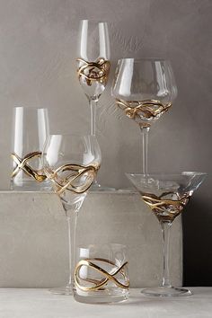 four wine glasses with gold rings on them