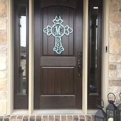 the front door is decorated with an iron cross