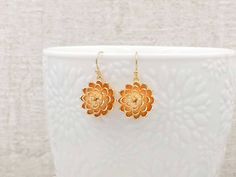 "These are pair of gorgeous and stunning gold flower earrings. The beautiful shining golden plated flowers have three layer of brush stroke textured petals with ball shaped stigma stems. The curve of the petal enhanced the inner shadow, in which emphasized the dimension of the flower. They hang underneath brass French ear wires. The earrings measure approximately (33mm) 1.3 inches from the top of the ear wires to the bottom of the flowers. They are perfect for many occasion and everyday wear. Th Gold Flower Bridal Earrings, Gold Flower Bridal Earrings For Anniversary, Dainty Gold Bridal Earrings With Ear Wire, Gold Flower Earrings With Ear Wire, Yellow Gold Flower-shaped Bridal Earrings, Gold Flower-shaped Earrings With Flower Charm, Gold Dangle Flower Earrings For Wedding, Gold Flower Earrings With Charm, Delicate Gold Flower Earrings For Anniversary