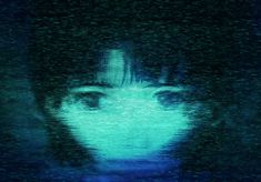 a blurry image of a woman's face in the dark with blue light