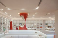 the interior of a store with white shelves and red sculptures on the wall behind it