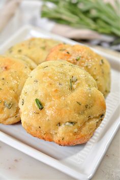 three small muffins on a white plate with green beans