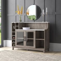 a wooden cabinet sitting in front of a mirror on top of a wall next to a rug