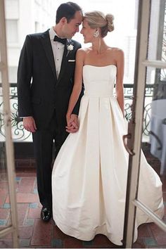 a bride and groom standing in front of a window