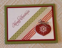 a christmas card with a red ornament hanging from it's side on a table