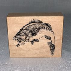 a small wooden box with a fish on it