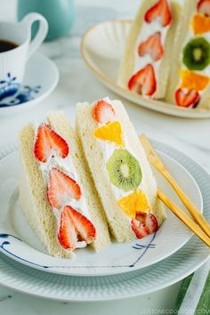 two slices of cake with fruit on them and chopsticks next to each other