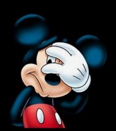 an image of mickey mouse in the dark with his head tilted to the side and eyes wide open