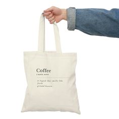 a person holding a tote bag that says coffee and it is in the air