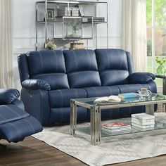 a living room with blue leather furniture and a glass coffee table in front of the couch