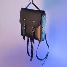 The Blackout Harness Mini Backpack is a medium-sized bag for running around and doing all the things. The black vegan leather and shiny black PVC pair nicely together for a pleasing black-on-black texture contrast. Features two buckle front closures, detachable shoulder straps can convert to a shoulder strap by attaching to the side d-rings, and a handle on top.Silver toned hardware.BAG DIMENSIONSHeight:  9.75 inches (20.32 cm)Width:  8.75 inches (21.59 cm)Depth: 2 inches (10.16 cm)All pieces ar Leather Streetwear Backpack, Leather Backpack For Streetwear, Leather Streetwear Standard Backpack, Punk Style School Satchel Bag, Gothic Black Standard Backpack, Black Gothic Standard Backpack, Alternative Style Everyday Backpack, Gothic Standard Backpack For Everyday Use, Punk Style Standard Backpack For Everyday Use