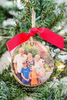 an ornament hanging from a christmas tree with a red ribbon on it's side