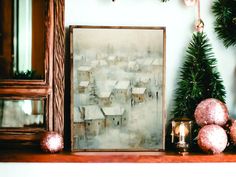 a painting sitting on top of a mantle next to a christmas tree and other decorations