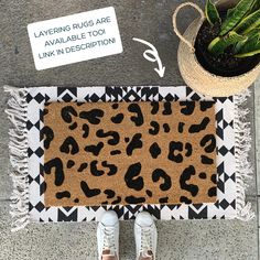 a leopard print rug and potted plant on the ground next to a door mat