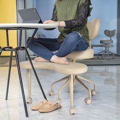 a woman sitting at a table using a laptop computer