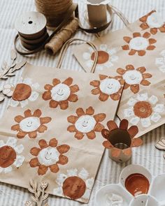 two brown paper bags sitting on top of a table next to twine spools