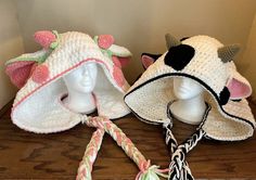 two crocheted hats on top of a wooden table next to a white mannequin's head