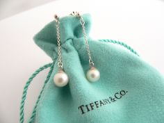 Overview:Time to pull your hair back and show off your fantastic earrings! Here is an awesome pair of Tiffany earrings that you will never want to take off! Offered for sale is a gorgeous Tiffany & Co. Sterling Silver Pearls by the Yard dangling earrings. The piece is crafted from bright and substantial Tiffany silver. Dangling from the earrings is a beautiful creamy pearl - super classic and elegant look! It is a wonderful pair of earrings that fits a lifestyle on the go -- the pair can be worn Tiffany Pearl Earings, Tiffany & Co Heart Earrings, Pearl Jewelry Tiffany & Co., Pearl Earrings Studs, Tiffany And Co Earrings, Tiffany Earrings, Hair Back, Earrings Studs, Gift Pouch