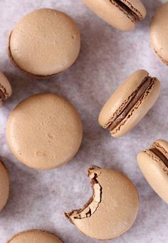 several macaroons are arranged on a piece of parchment paper with one half eaten