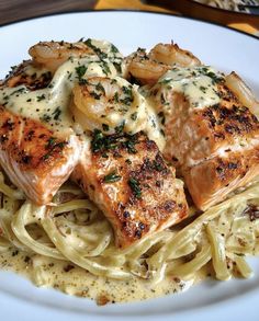 a white plate topped with pasta and meat covered in sauce