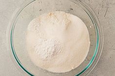 a glass bowl filled with flour on top of a table