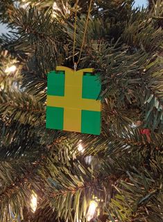 a green and yellow ornament hanging from a christmas tree