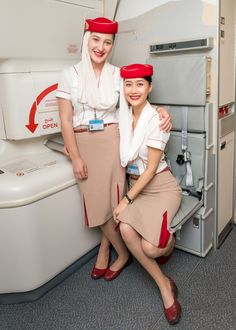 two women in airline uniforms posing for the camera