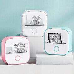 three white and pink boxes with pictures on the front, one has a flower in it