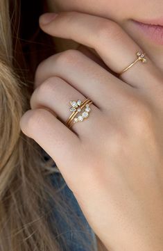 a close up of a person's hand wearing a gold ring with flowers on it