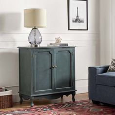 a living room with a blue couch, chair and lamp on the side walk way