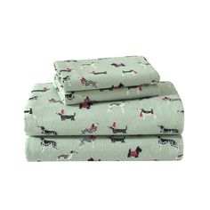 three sheet sets with dogs on them in mint green and black, the sheets are folded up