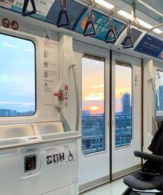 the inside of a train car with many windows and seats on it, looking out at city skyline