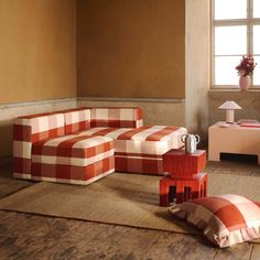 an orange and white checkered couch sitting on top of a rug next to a table