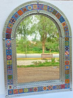 an arched window with a bench in front of it and a tree on the other side