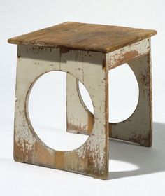 an old wooden stool that has been painted white and is shaped like a square with a hole in the middle