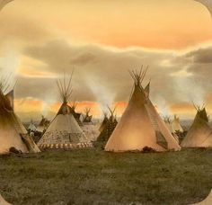 a group of teepees sitting next to each other on top of a field