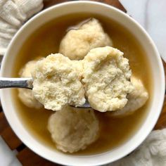 two scoops of ice cream in a white bowl on top of a wooden cutting board