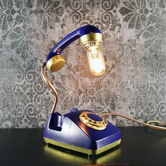 a blue and gold phone sitting on top of a table next to a light bulb