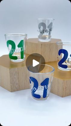 three shot glasses with numbers on them sitting on top of a wooden block and stand