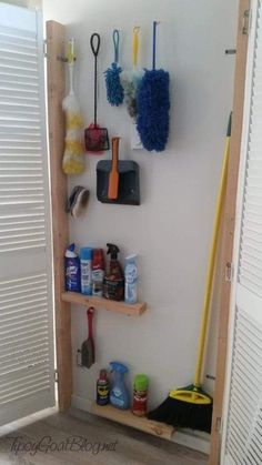 there is a shelf with cleaning supplies and brooms on it next to the door