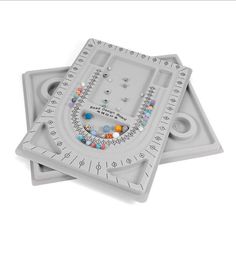 two plastic trays with different designs and beads on them, one for each individual